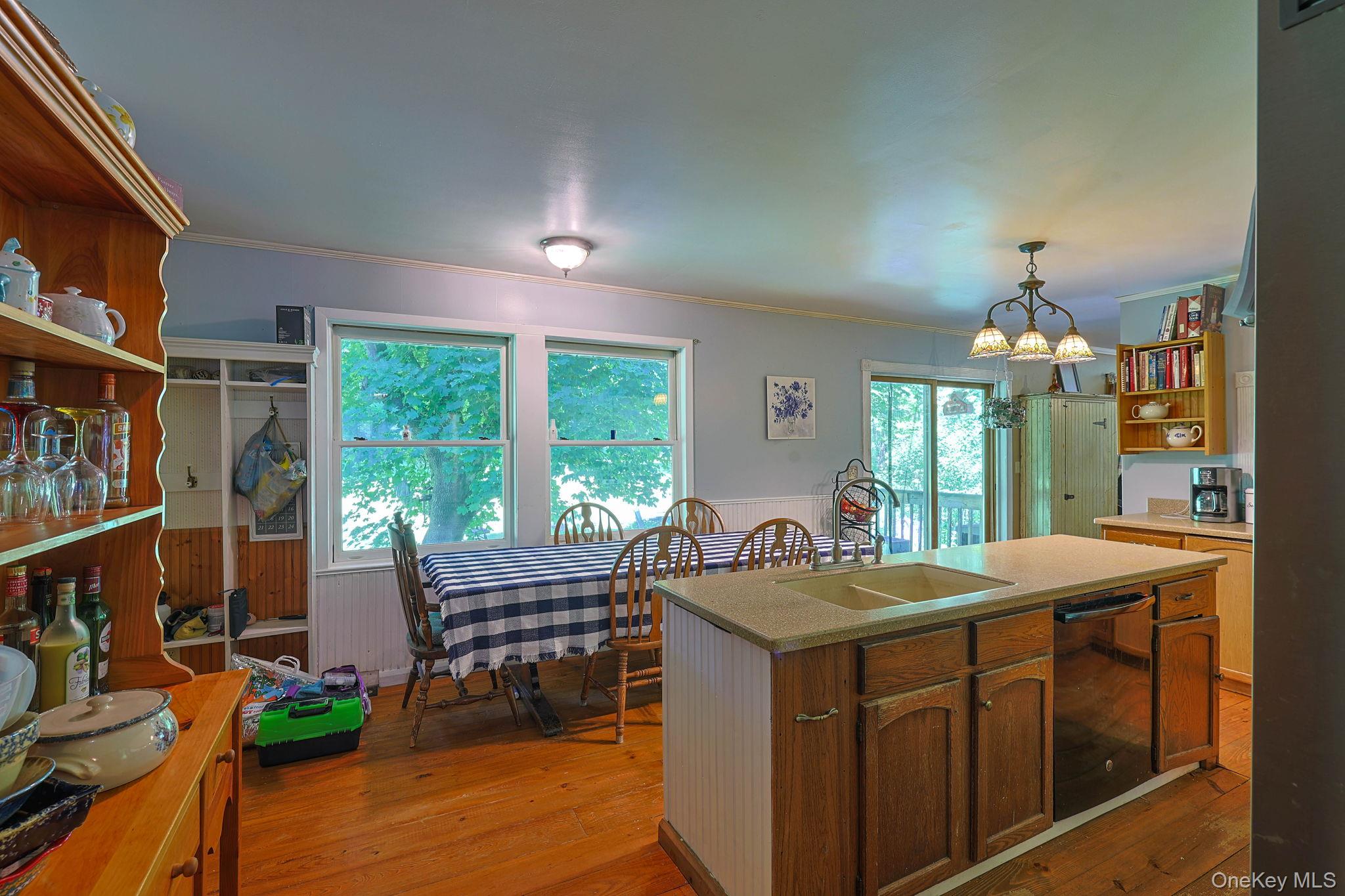 646 County Rte 93 Slate Hill, NY 10973 - Photo 8 of 21 Kitchen featuring wood-finish flooring, an island with an integrated sink, a built-in dishwasher, and sliding glass doors