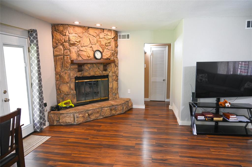 1352 Simpson Drive Hurst, TX 76053 - Photo 11 of 40 Corner fireplace with a stone surround and wood mantel