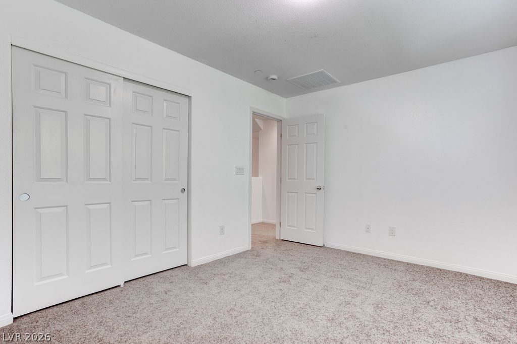 4650 Ranch House Road, Unit 47 North Las Vegas, NV 89031 - Photo 21 of 43 A well-maintained carpeted floor anchors this tidy, neutral-toned secondary bedroom, ready for personalization.