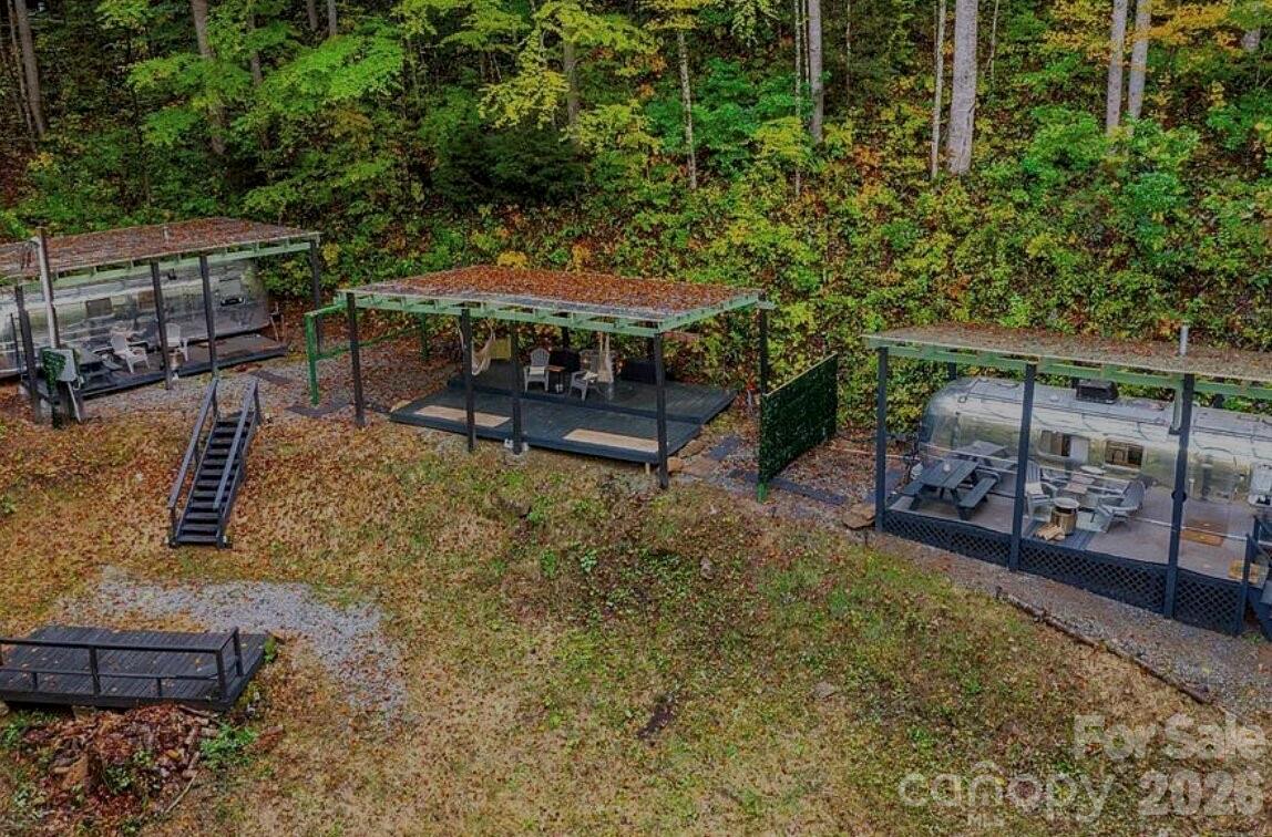 100 Locust Flats Road Highlands, NC 28741 - Photo 1 of 1 a view of a patio with table and chairs under an umbrella with a small yard
