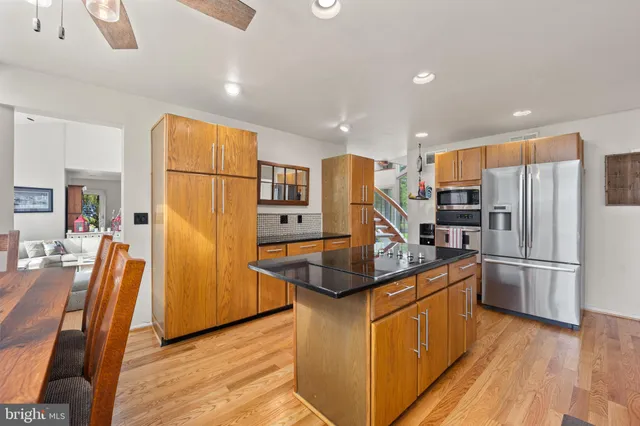 a kitchen with stainless steel appliances granite countertop a refrigerator a stove a sink dishwasher and a refrigerator