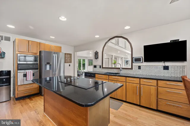 a kitchen with stainless steel appliances granite countertop a sink a stove and a refrigerator