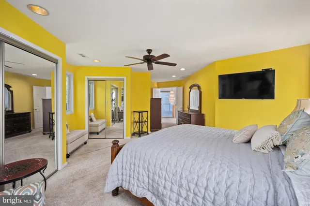 a bedroom with a large bed a flat tv screen and a walk in closet