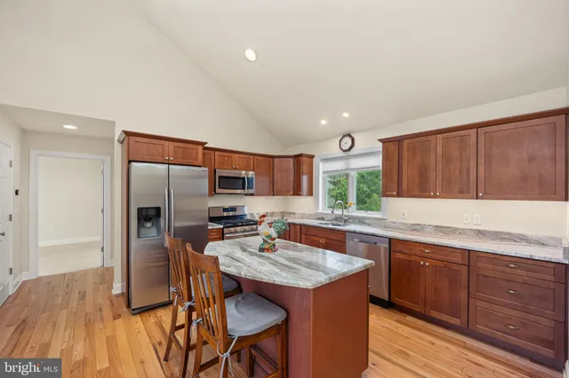 a kitchen with granite countertop a sink appliances and cabinets