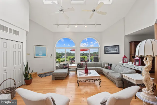 a living room with furniture a flat screen tv and a large window