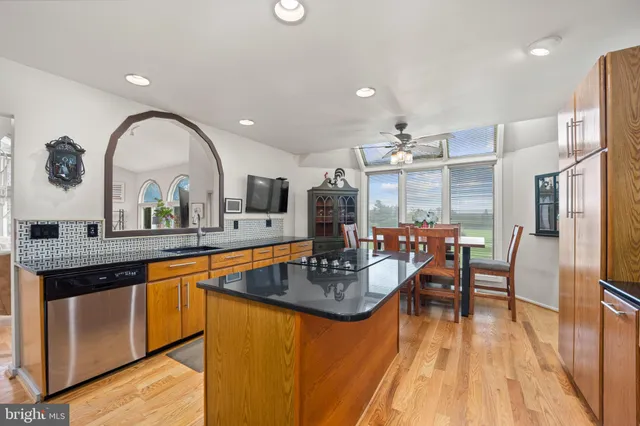 a kitchen with stainless steel appliances granite countertop a kitchen island a stove a table and chairs