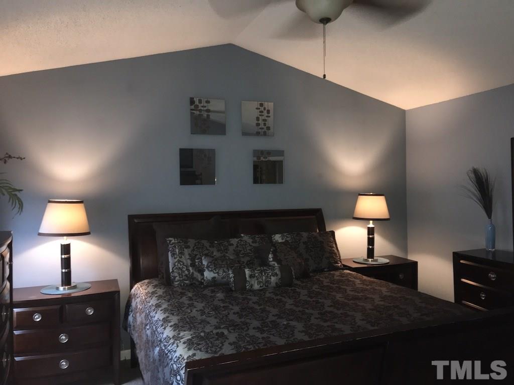 5213 Marthonna Way Raleigh, NC 27616 - Photo 7 of 15 a bedroom with a bed and a lamp