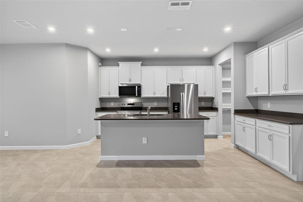 3352 Timber Xing Avenue Brandon, FL 33511 - Photo 6 of 35 a kitchen with stainless steel appliances granite countertop a refrigerator sink and microwave