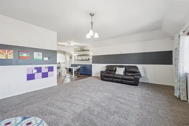 a living room with furniture and a chandelier
