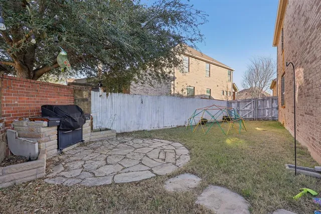 a view of a backyard with plants and a fire pit