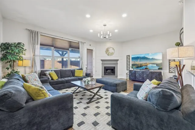 a living room with furniture fireplace and a potted plant