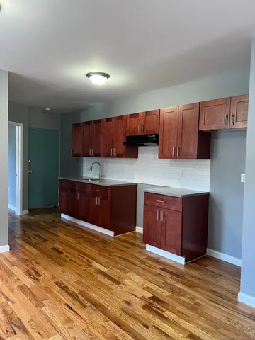 a kitchen with stainless steel appliances granite countertop a stove a refrigerator and a sink with wooden cabinets