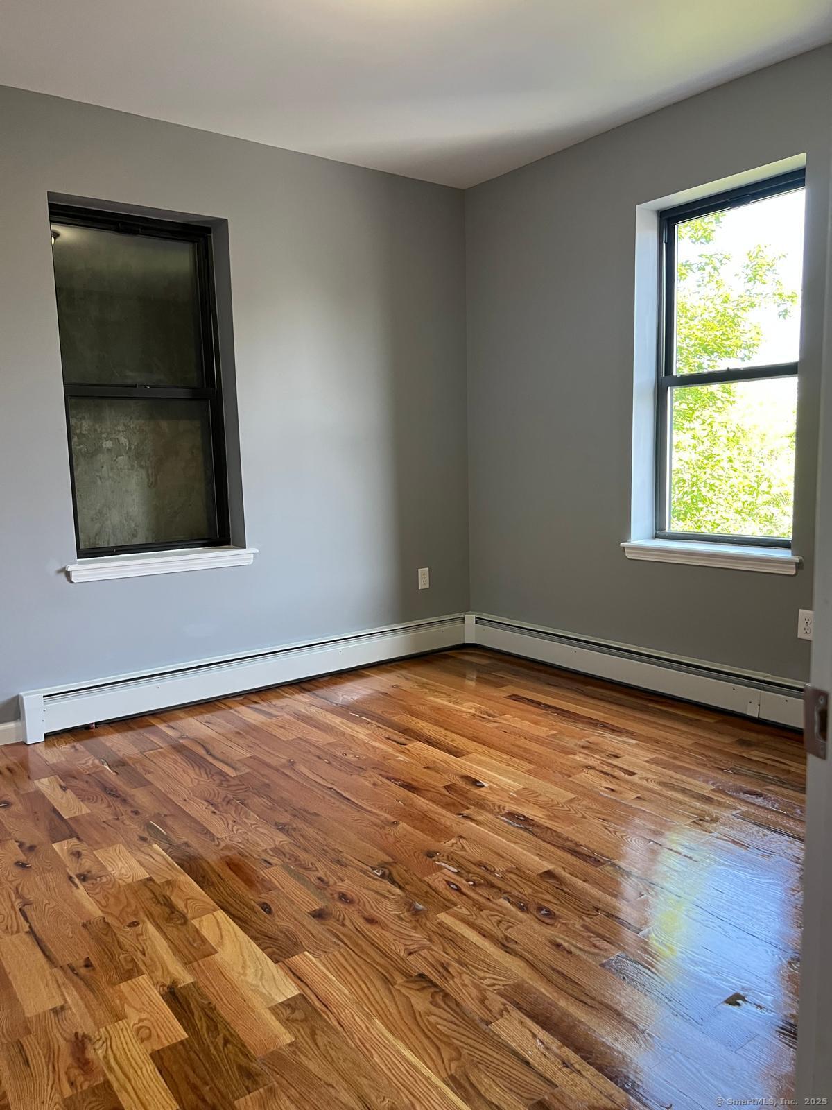 79 Barbour Street, Unit S2 Hartford, CT 06120 - Photo 4 of 7 a view of an empty room with wooden floor and a window