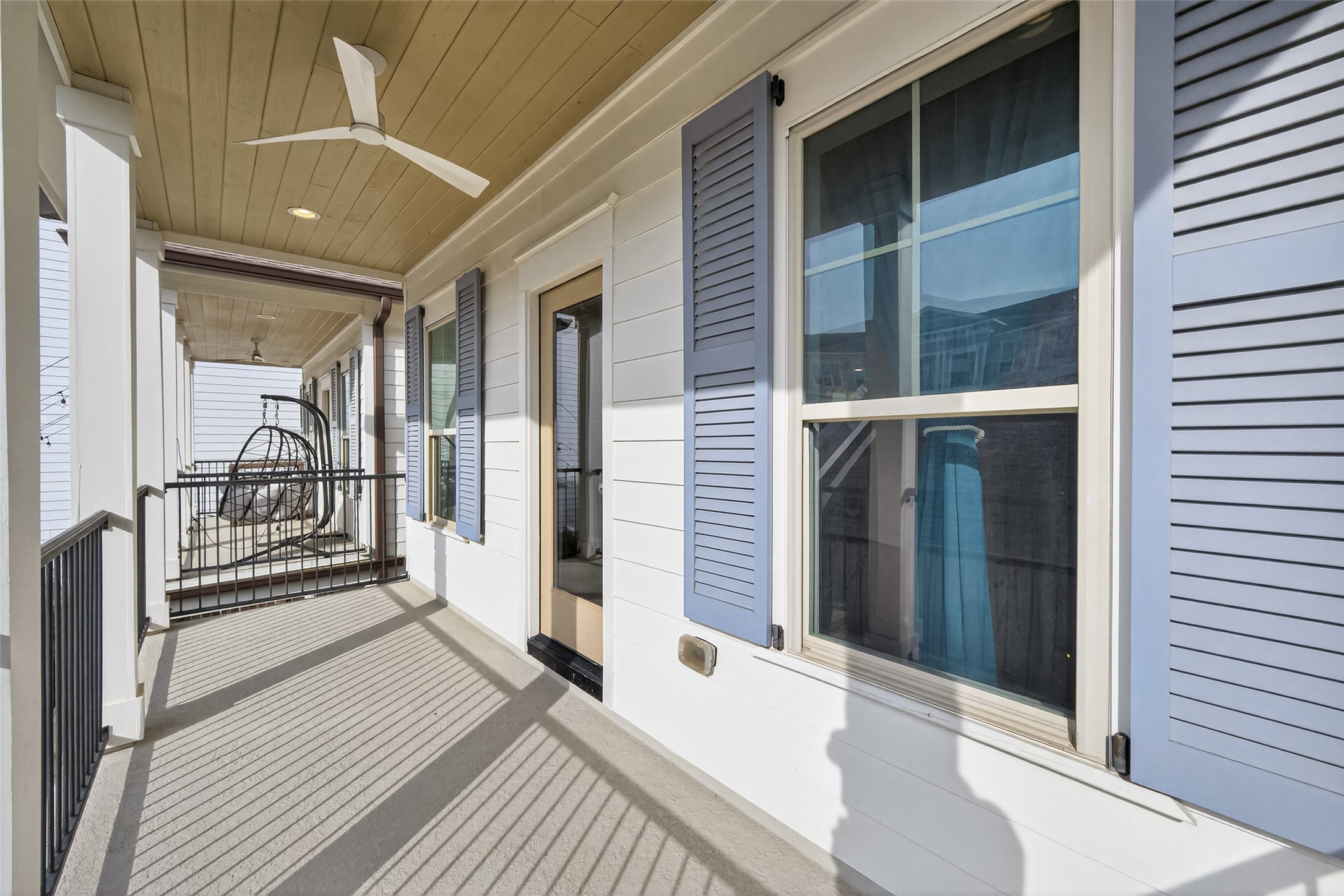 515 West 25th Street Houston, TX 77008 - Photo 17 of 35 Primary 18’8” x 5’4” covered balcony features a Minka-Aire medium ceiling fan in flat white, recessed lighting, iron railing, and a tongue-and-groove ceiling, all overlooking the beautifully designed front yard.