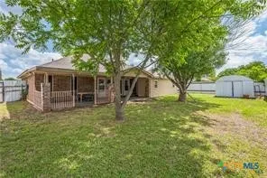 a view of a house with backyard and a tree