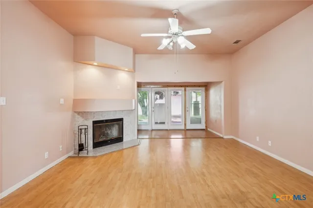 a view of an empty room with a fireplace and a window