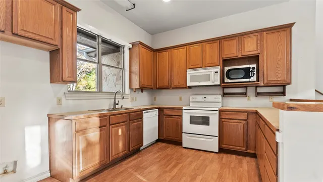 a kitchen with stainless steel appliances granite countertop wooden cabinets and a stove top oven