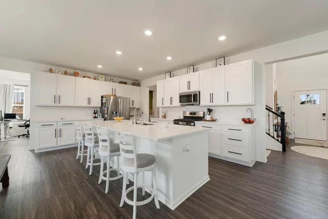 a kitchen with white cabinets and stainless steel appliances