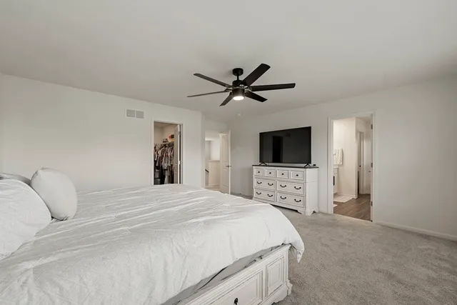 a bedroom with a large bed and a flat screen tv