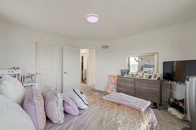 a bedroom with furniture and a flat screen tv