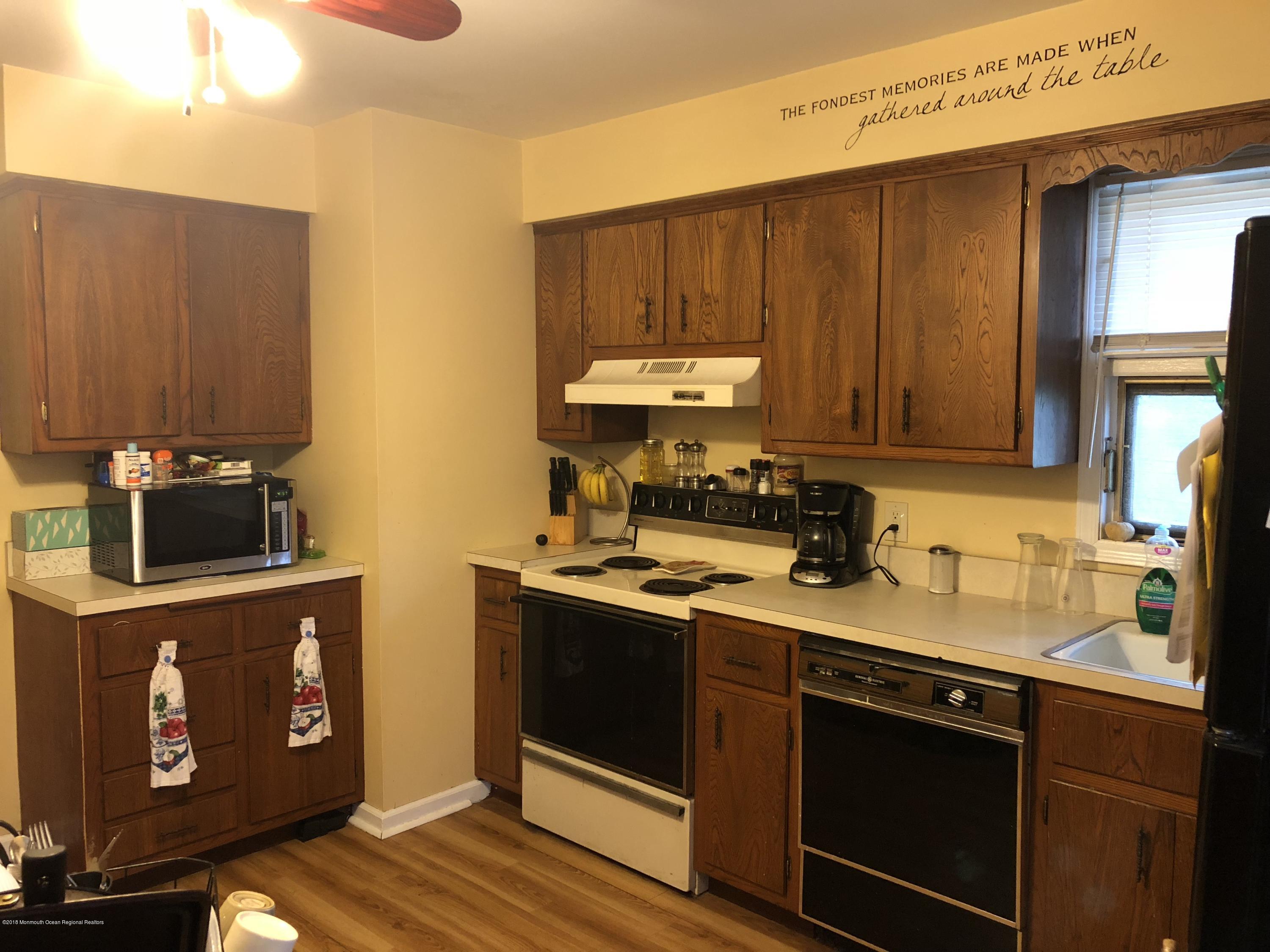 196 Ravine Drive Matawan, NJ 07747 - Photo 8 of 8 a kitchen with stainless steel appliances granite countertop a stove a sink and a microwave