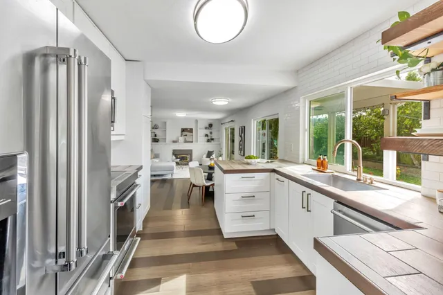 a kitchen with counter top space appliances and windows