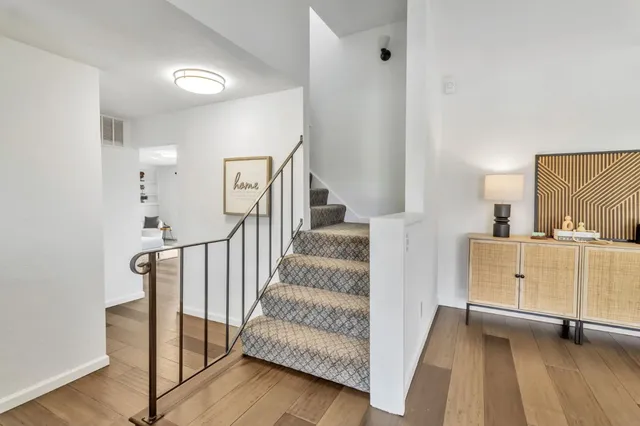a view of a bedroom with wooden floor and windows