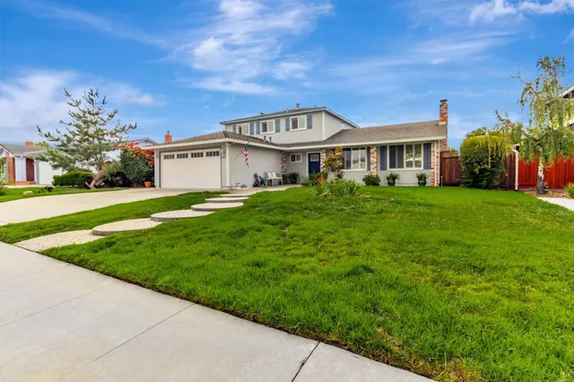 a view of a house with a big yard and potted plants