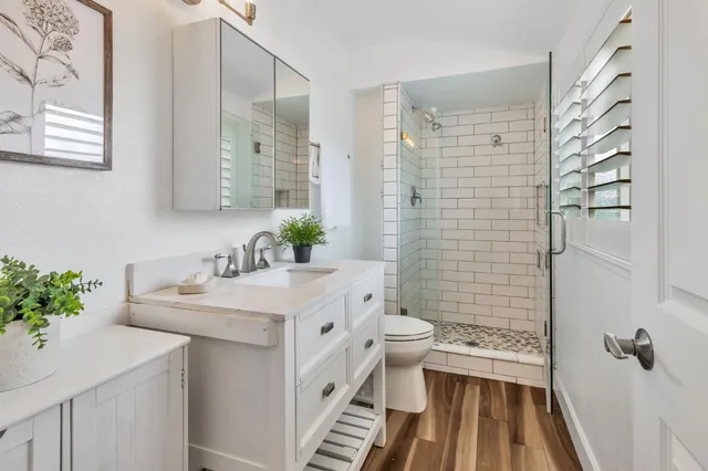a bathroom with a sink toilet a mirror and shower