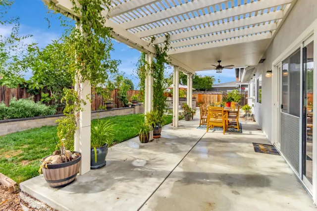 a view of a patio with table and chairs potted plants with wooden floor and fence