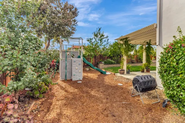 a backyard of a house with large trees and plants
