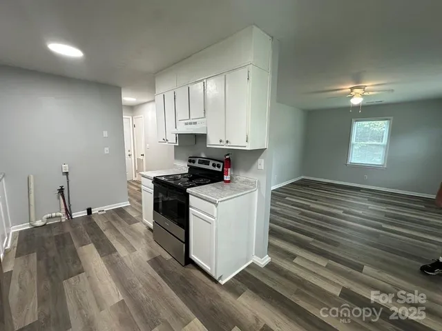 a kitchen with granite countertop white cabinets and appliances