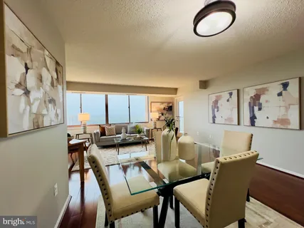 a view of a dining room with furniture a rug and a window