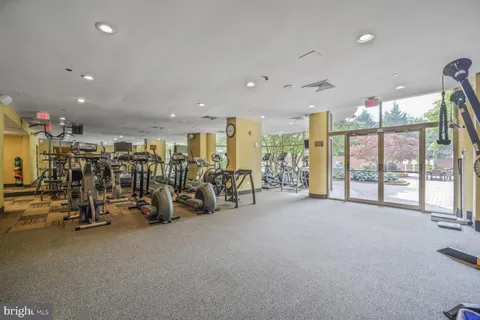 a view of a room with gym equipment and large mirror