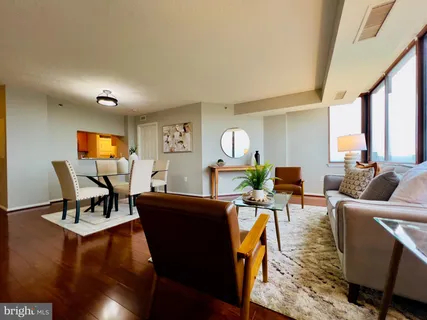 a living room with furniture and a wooden floor