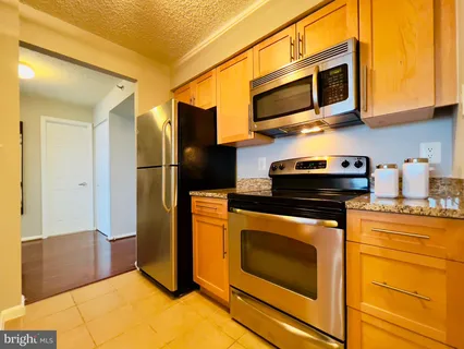 a kitchen with stainless steel appliances granite countertop a stove microwave and refrigerator