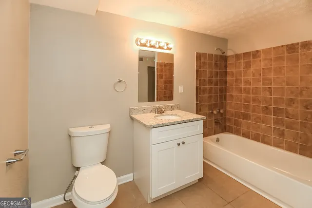 a bathroom with a toilet a sink a mirror a bathtub and shower