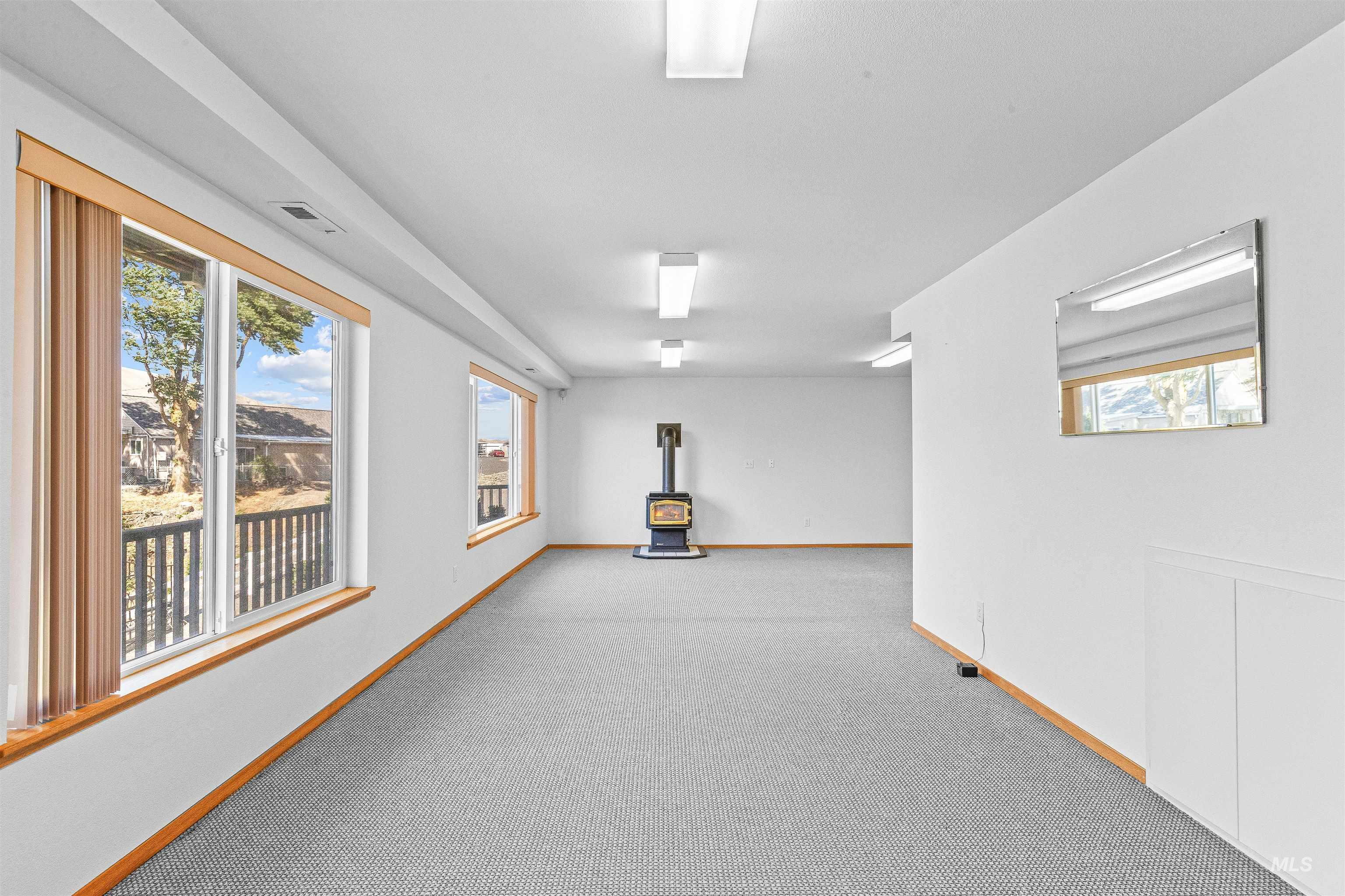1962 Golfview Drive Clarkston, WA 99403 - Photo 28 of 35 Empty room featuring a wood stove and carpet floors