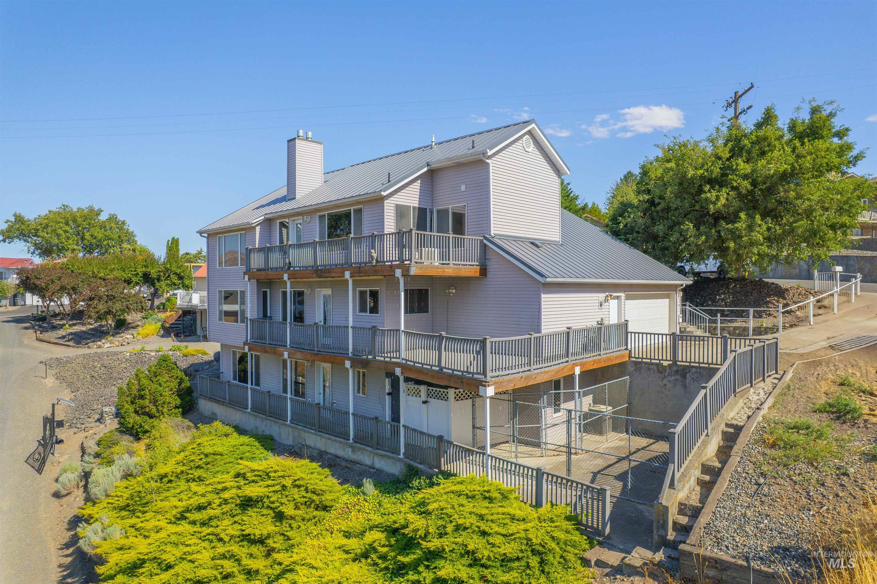 1962 Golfview Drive Clarkston, WA 99403 - Photo 3 of 35 Back of house featuring a metal roof, a chimney, a balcony, and a standing seam roof