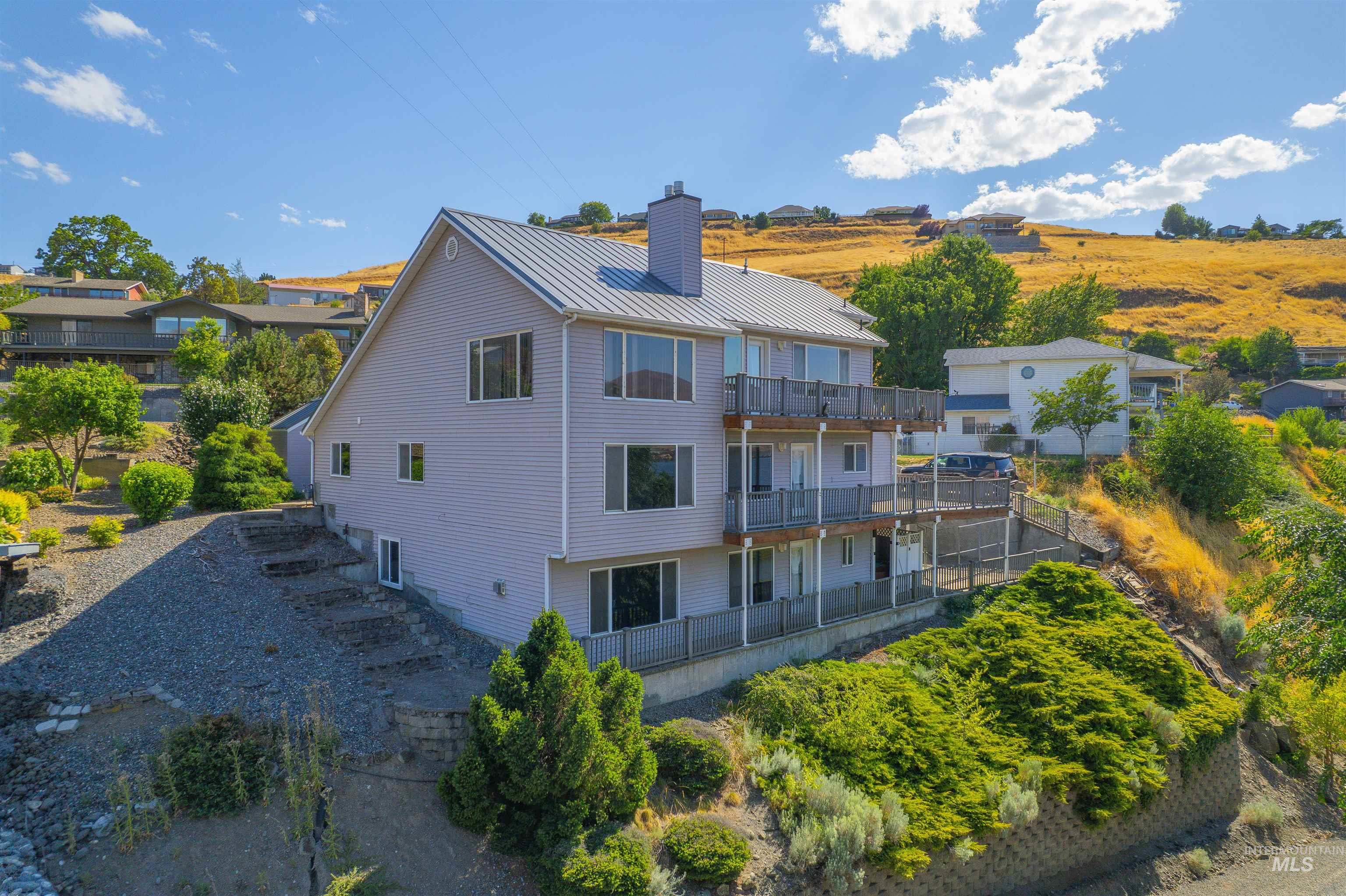 1962 Golfview Drive Clarkston, WA 99403 - Photo 4 of 35 Back of property featuring a balcony, a chimney, and a metal roof