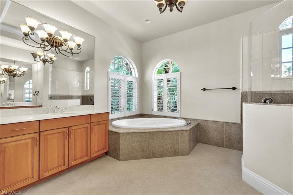3331 Sanctuary Point Fort Myers, FL 33905 - Photo 29 of 50 a spacious bathroom with a double vanity sink a large mirror a bathtub and window