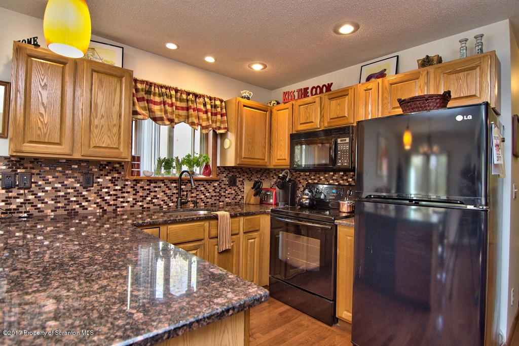 3304 Northgate Road Lake Ariel, PA 18436 - Photo 12 of 26 a kitchen with stainless steel appliances granite countertop a refrigerator a stove and a sink with wooden floor