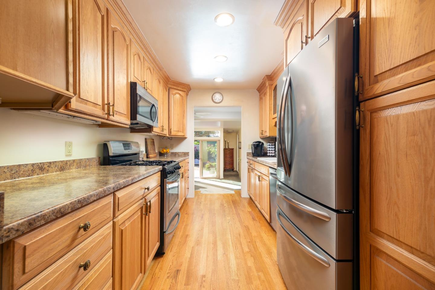 26436 Oliver Road Carmel, CA 93923 - Photo 13 of 25 a kitchen with stainless steel appliances granite countertop a refrigerator a oven and white cabinets with wooden floors