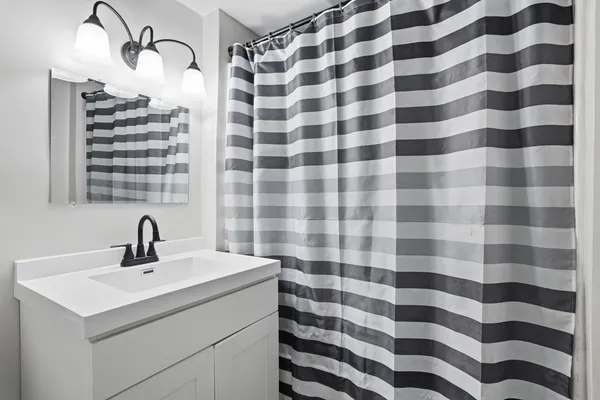 a bathroom with a sink a mirror and shower