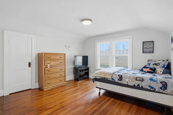 a bedroom with a bed and wooden floor