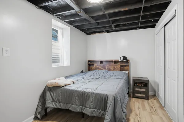 a bedroom with a bed with wooden floor