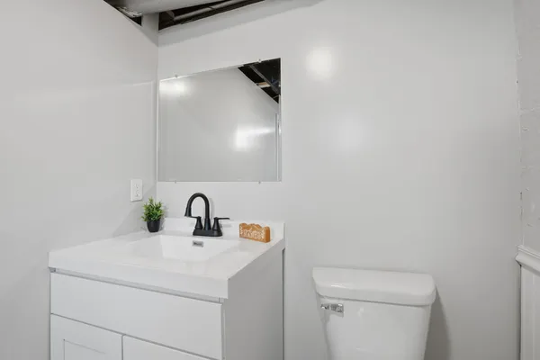 a bathroom with a toilet sink and mirror