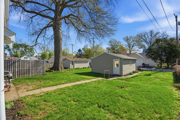 a view of a house with a yard and a large tree