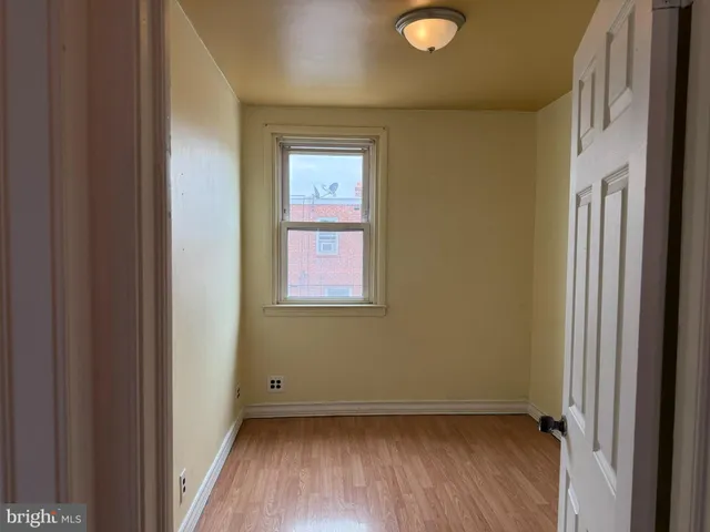 a view of a small space with wooden floor and a window