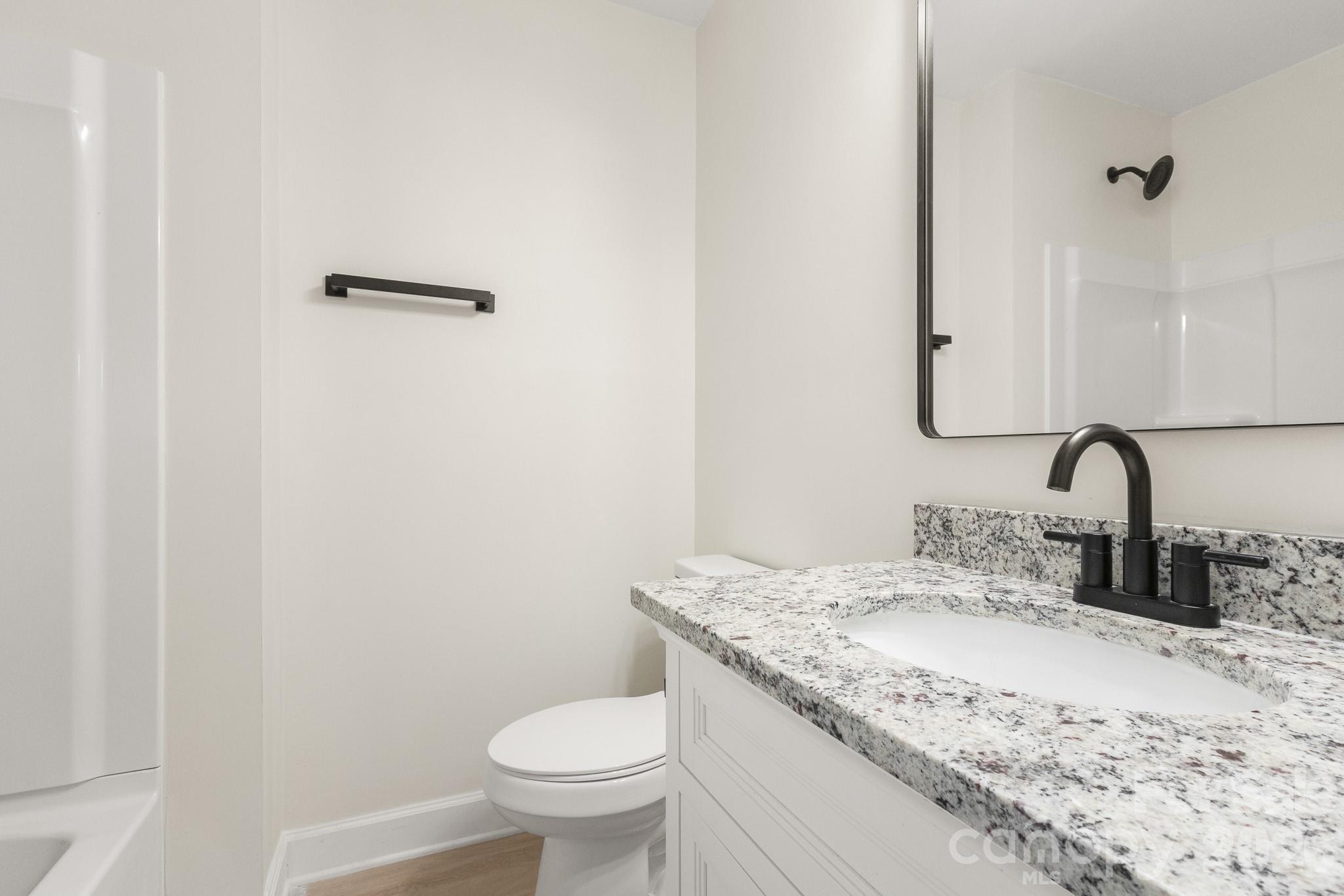 1152 Mt Holly Road Rock Hill, SC 29730 - Photo 24 of 41 a bathroom with a granite countertop sink a toilet and a mirror
